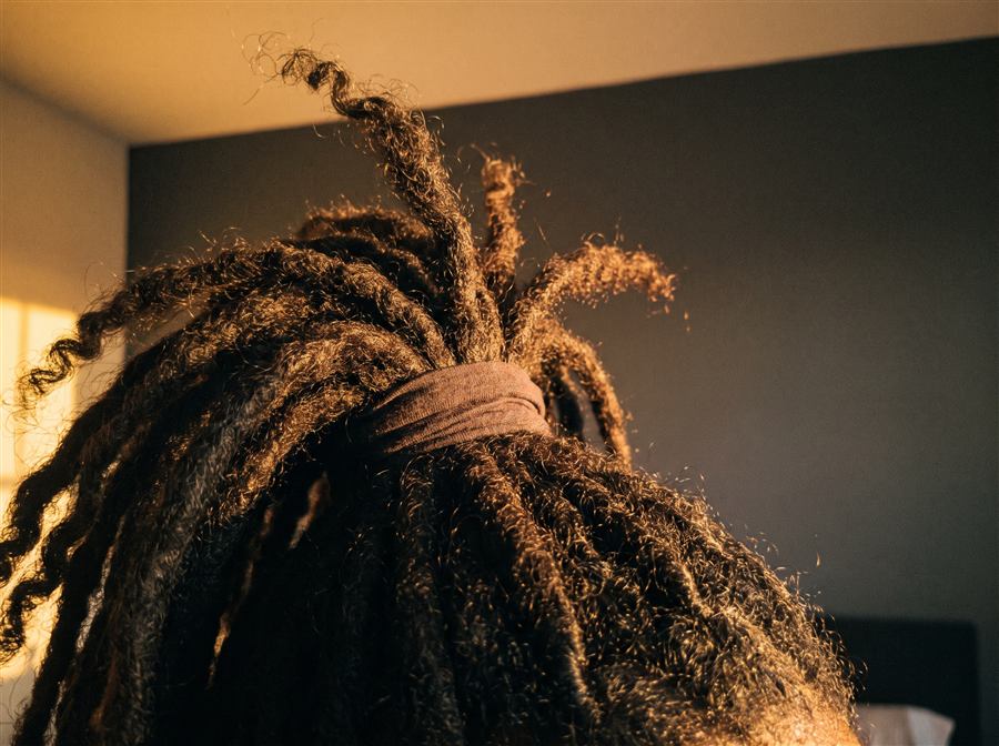 Dreadlocks gathered into a neat high ponytail, wrap secured tight at the root
